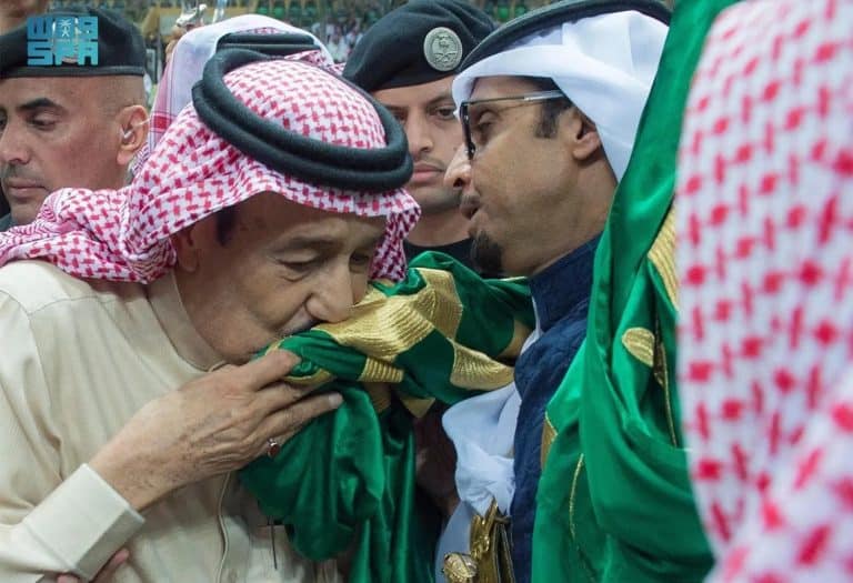خادم الحرمين الشريفين يقبل العلم الوطني